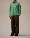 Light green lightweight jacket by Alessi with a C.P. Company pocket logo and sleeve badge, styled with dark cargo pants.