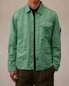 Mint green crinkled utility jacket by Alessi, featuring snap buttons, utility pockets, embroidered C.P. Company logo, and sleeve badge.