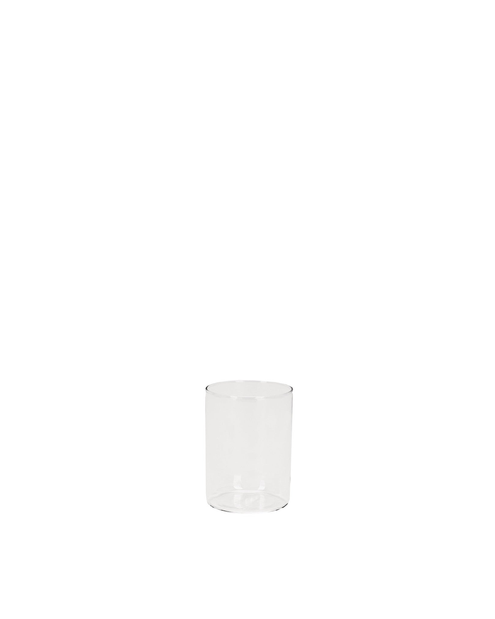 Clear cylindrical glass spare part by Alessi, empty and transparent.