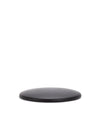 Dark round spare part by Alessi with visible wood grain texture, viewed at a low angle.