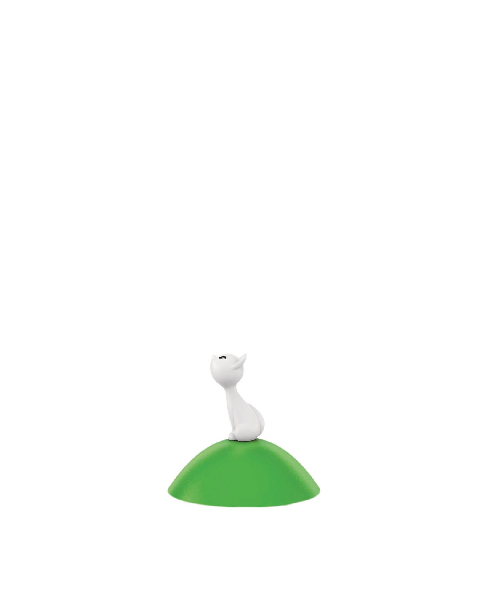 White cat-like Spare Part by Alessi, sitting on a smooth green mound.