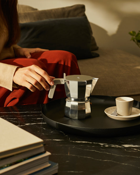 Eine innovative Interpretation der klassischen Mokkakanne. Dieser Espressokocher aus Aluminium hat einen flachen Deckel, der als Tassenwärmer dient.